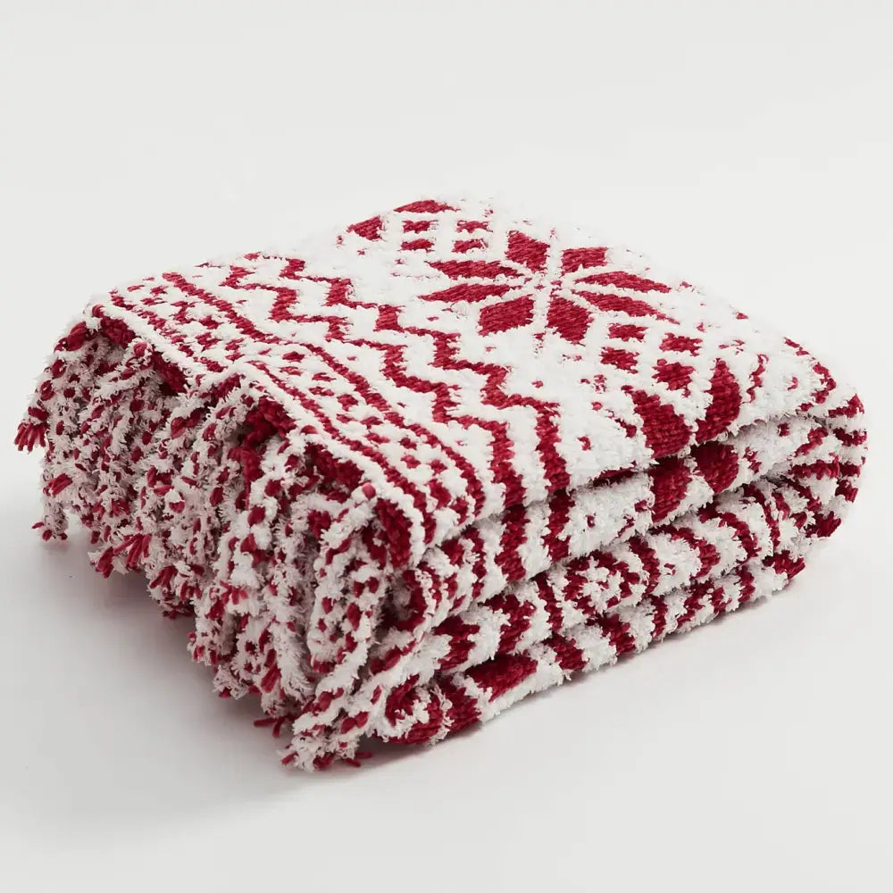A cozy red and white decorbites christmas chunky knit blanket with festive geometric pattern and fringed microfiber edges