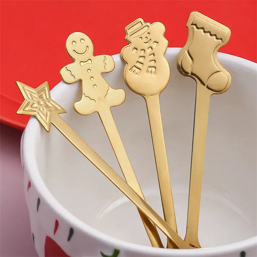 Set of four gold-colored stainless steel christmas coffee spoons with festive gingerbread, snowman, stocking, and star designs