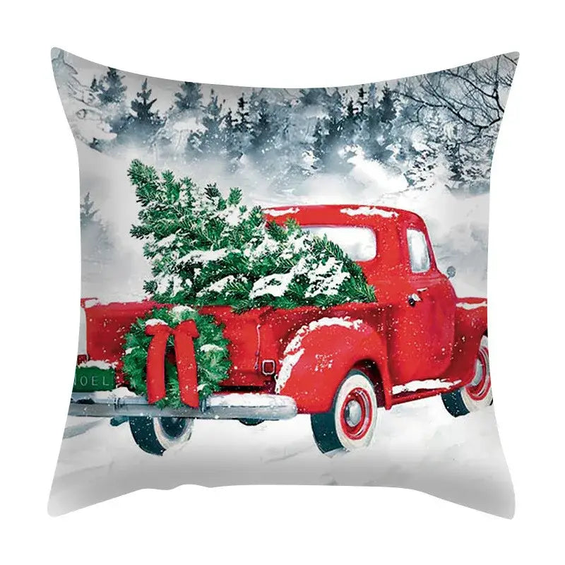 Red vintage truck carrying snow-dusted christmas tree and wreath on back side of decorbites christmas cushion cover set