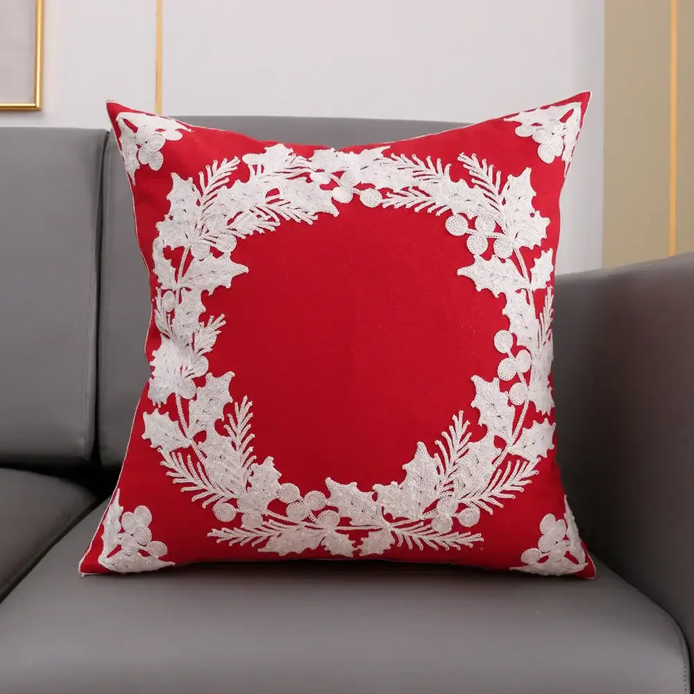Red cushion cover with white embroidered holly and berry wreath design from decorbites christmas décor collection