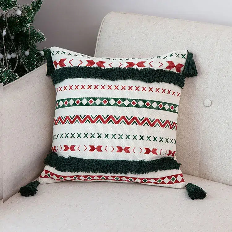 A festive white decorbites christmas decoration cushion cover with red green geometric patterns and handmade dark green tassels