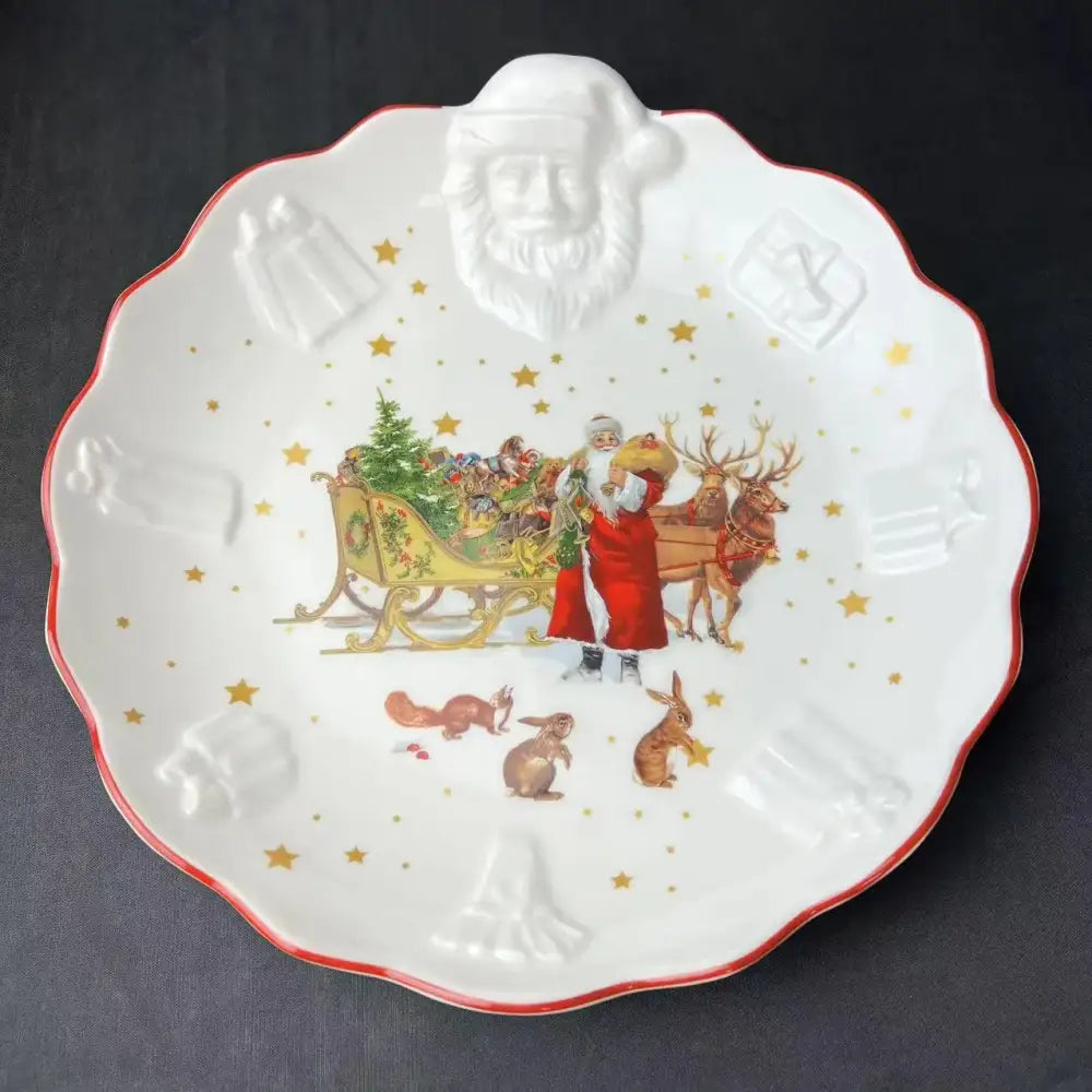 White ceramic christmas plate with red rim embossed santa face and santa sleigh illustration in decorbites christmas dinnerware set