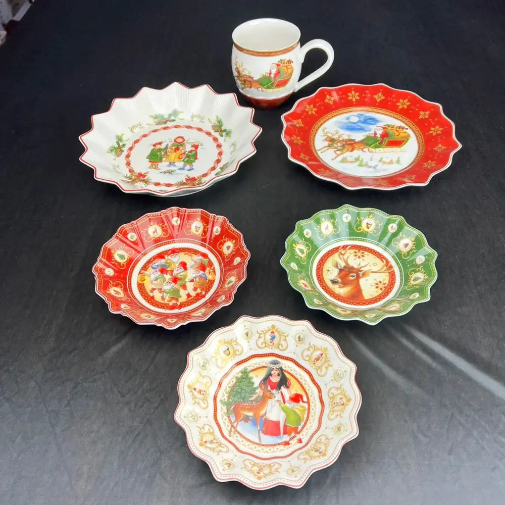 A festive porcelain mug with gold trim and santa claus scene from the decorbites christmas dinnerware set