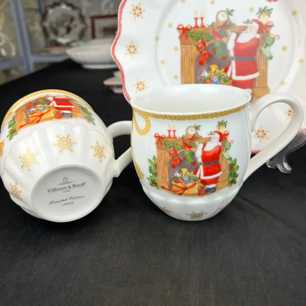 White ceramic mug with gold trim featuring santa by fireplace from villeroy & boch 2019 decorbites christmas dinnerware set
