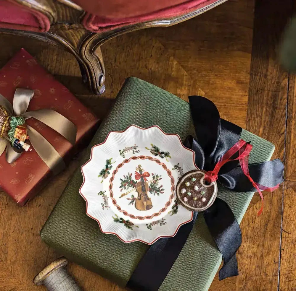 White ceramic plate with scalloped edges featuring a violin and holly design from decorbites christmas dinnerware set