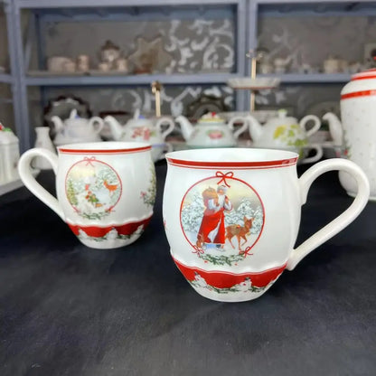 White ceramic mugs with red decorative bands and festive illustrations from the decorbites christmas dinnerware set