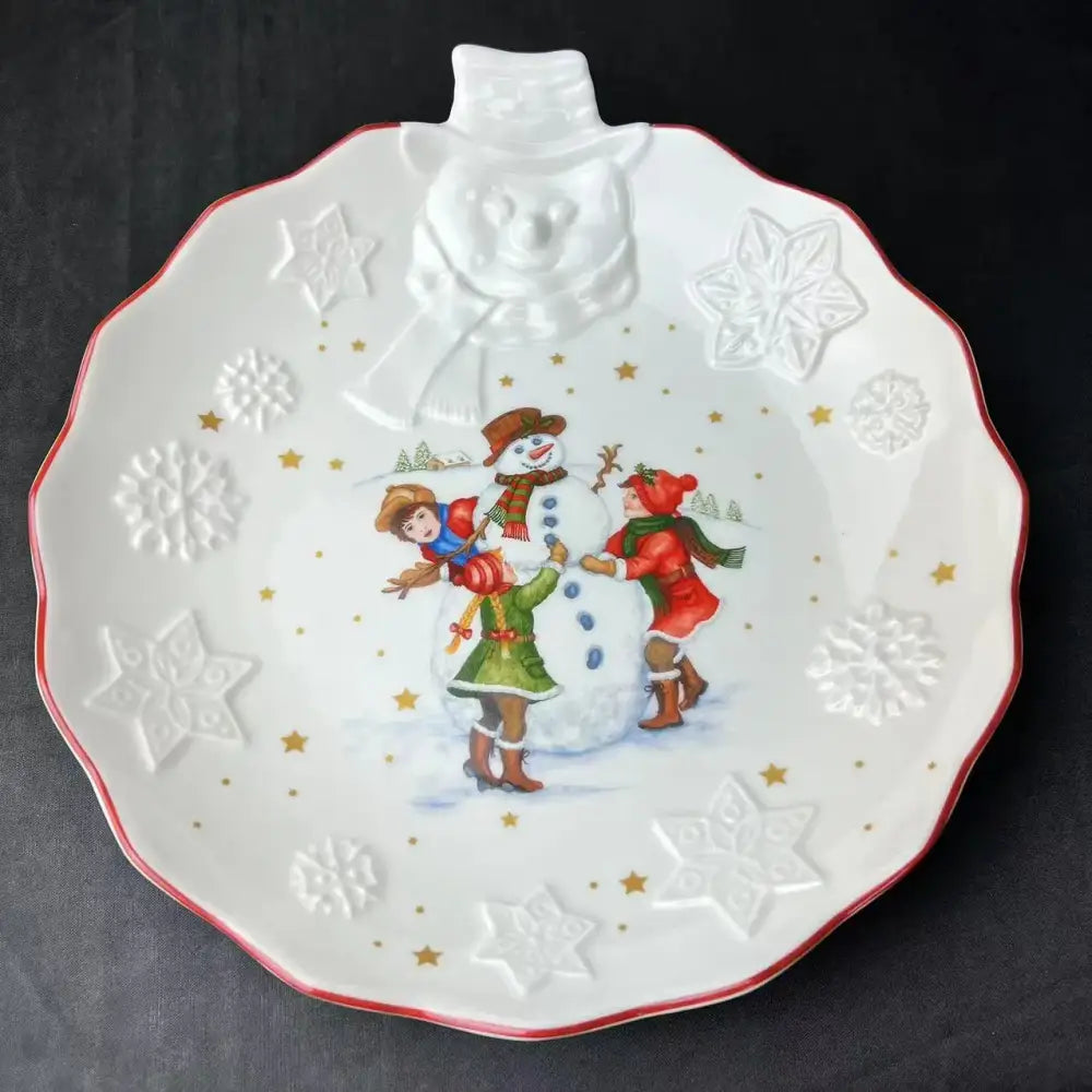 White ceramic holiday plate with raised snowman handle and embossed winter scene from decorbites christmas dinnerware set