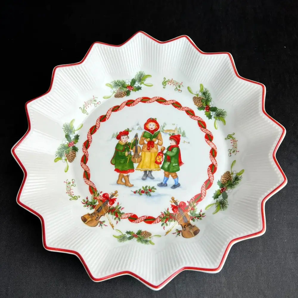 White ceramic scalloped pie plate with red trim and festive children illustration from decorbites christmas dinnerware set