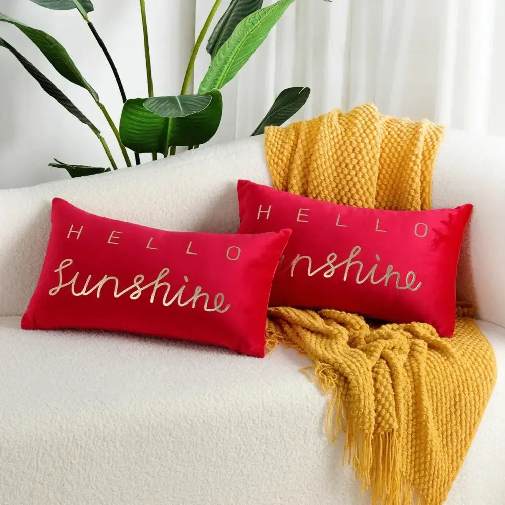 Two vibrant red velvet throw pillows with hello sunshine embroidered in metallic gold thread decorbites christmas elk red letter design