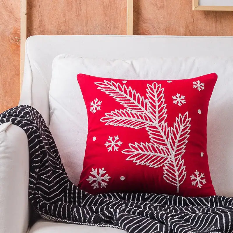 Red cushion pillow cover featuring white embroidered pine branches and snowflakes from decorbites christmas embroidered cotton collection