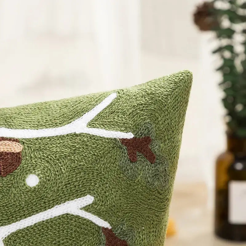 Green embroidered cushion cover with white and brown tree branch design from decorbites christmas embroidered collection