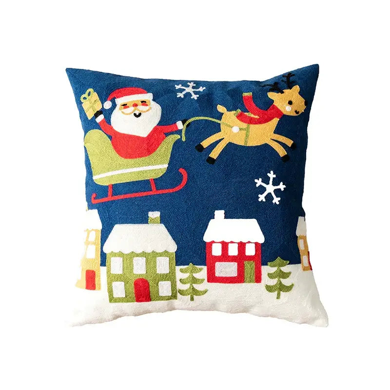 Blue christmas embroidered pillow cover by decorbites featuring santa sleighing with reindeer over snow houses