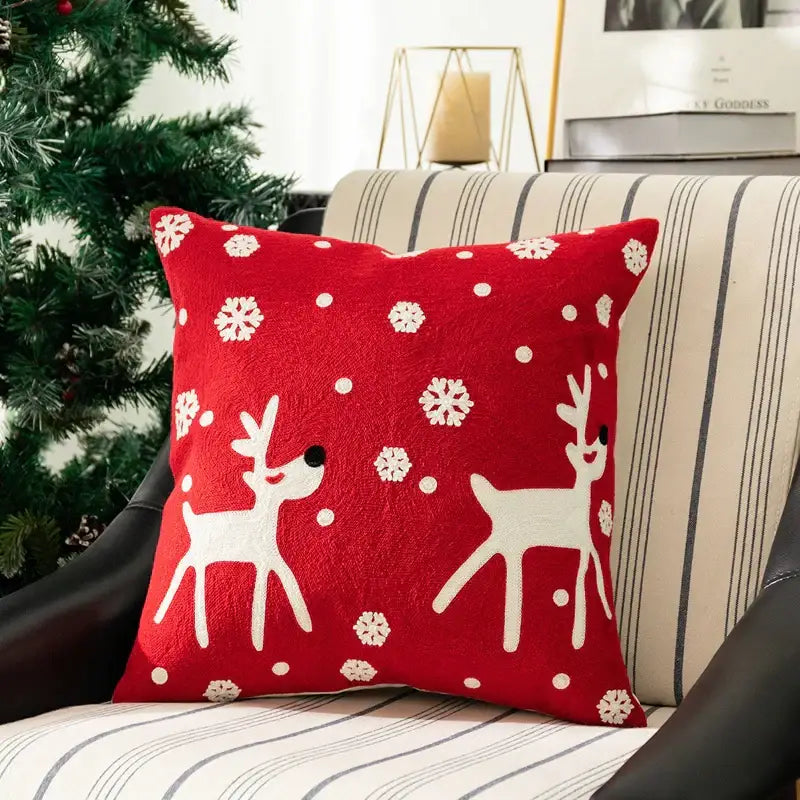 Red holiday pillow cover with white embroidered reindeer and snowflakes on plush fabric from decorbites christmas embroidered set