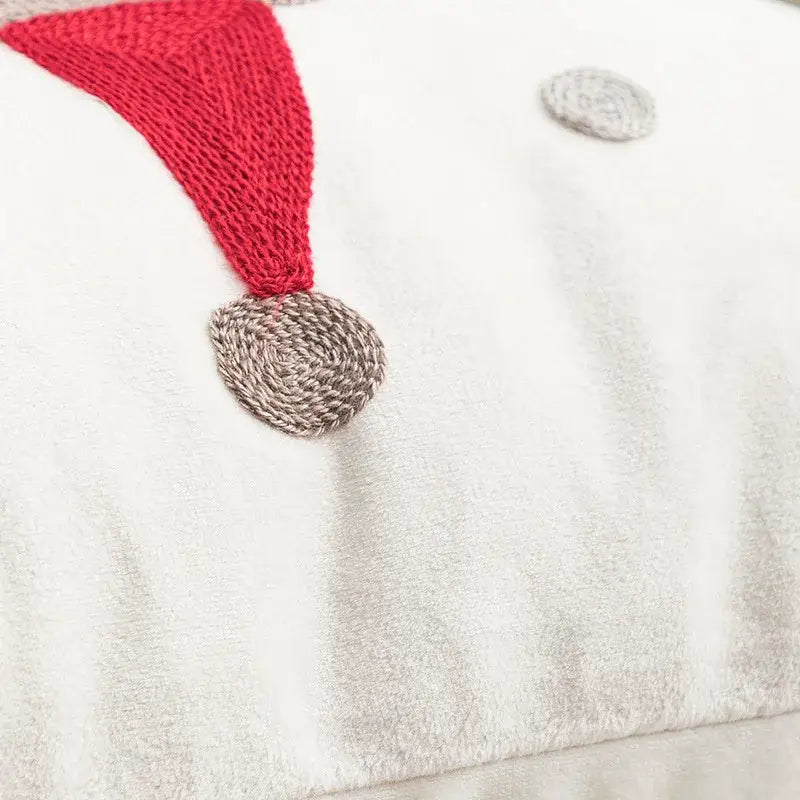 White plush snowman pillow with red knitted hat and gray nose featured on decorbites christmas embroidered red cushion cover