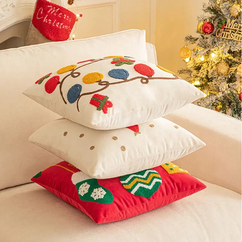 Stacked decorbites christmas embroidered pillow covers featuring red geometric and festive designs on plush fabric