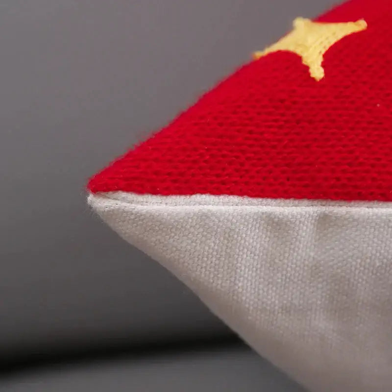 Red cushion cover with yellow star embroidery on textured fabric edged in white linen from decorbites christmas embroidery collection
