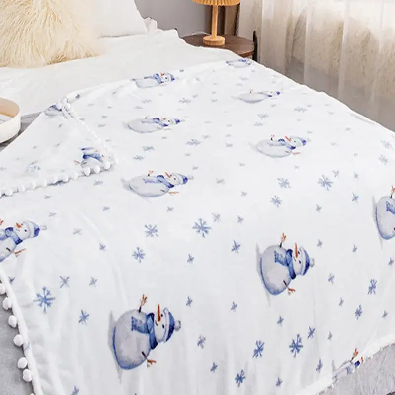 White decorbites christmas flannel blanket with blue snowmen pattern and plush pom-pom edging for winter use