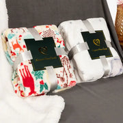 Two decorbites christmas flannel blankets with festive designs in cream and white plush for winter shawl and cushion use