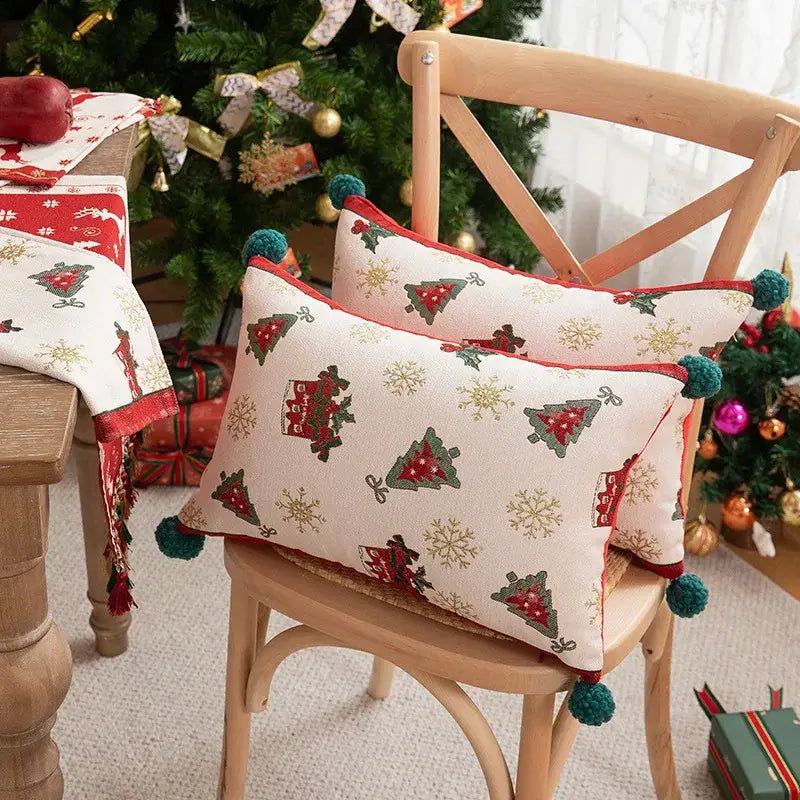 Cream-colored decorbites christmas jacquard pillow cover with red green tree patterns gold snowflakes and teal pom-poms