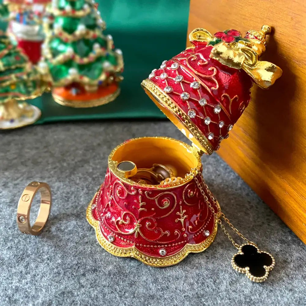 A red and gold ornate bell-shaped trinket box with enameled designs rhinestones and a black clover pendant chain decorbites christmas jingle