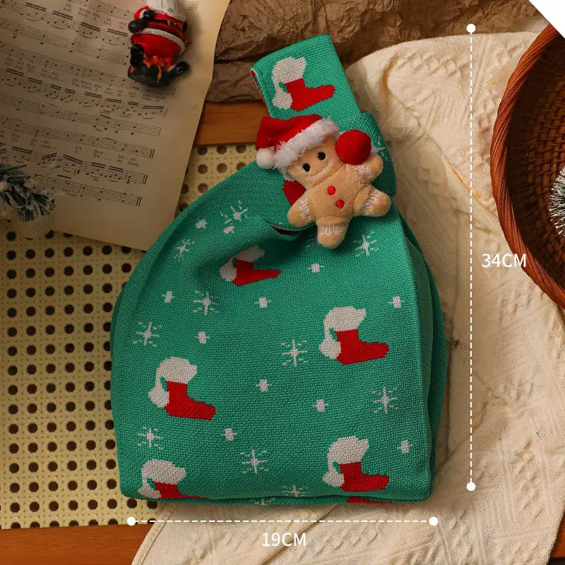 A festive green decorbites christmas knitted apple bag with red white stocking patterns and plush gingerbread doll