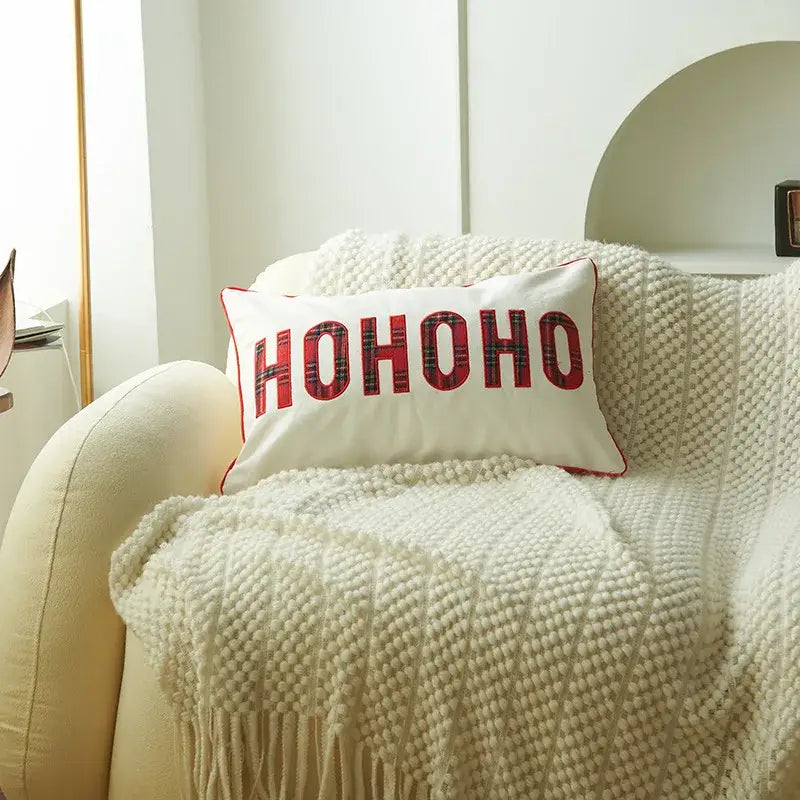 White rectangular pillow with red ho ho ho lettering and plaid pattern featuring decorbites christmas letter embroidery