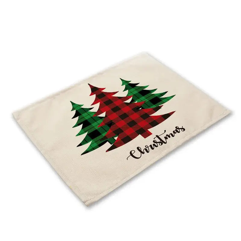 Beige linen dining table placemat with red and green plaid christmas trees and scripted christmas text from DecorBites™