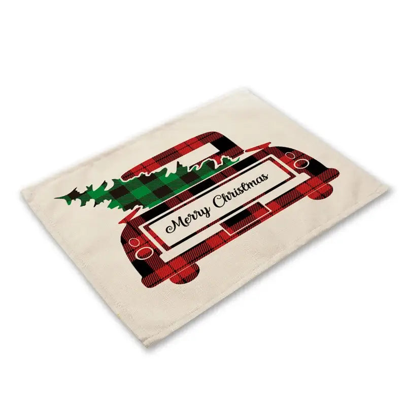 Cream-colored linen dining table mat featuring a red and black plaid truck carrying a green tree with merry Christmas text