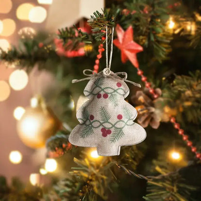 Beige linen printed pentagram sock ornament with green holly and red berries tied with rustic twine bow for christmas tree