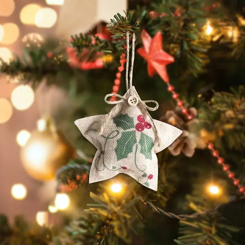 A white fabric pentagram sock decorated with green holly leaves red berries and a button for christmas tree decorations