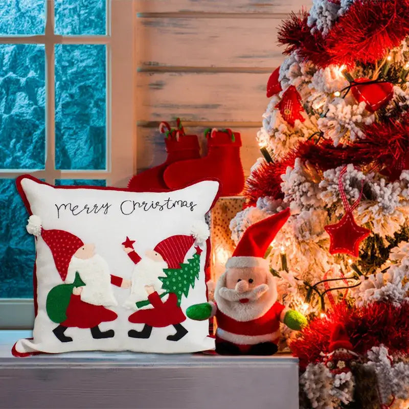 White christmas-themed pillow cover with embroidered santa figures red hats green trees and decorbites christmas patchwork design