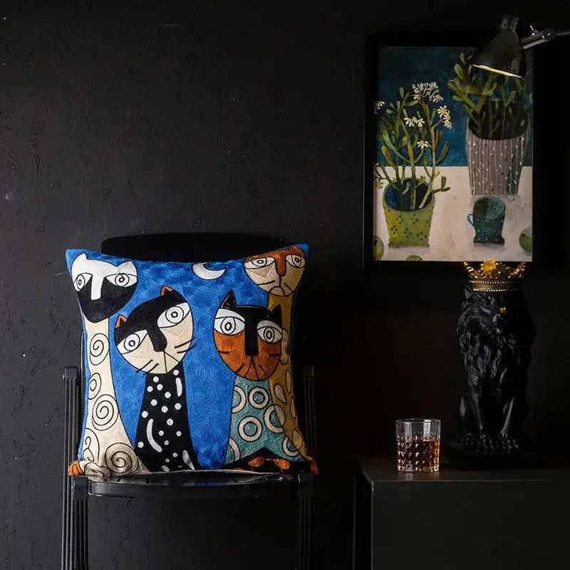 Blue embroidered cushion cover with stylized black white and orange cats in christmas picasso style by decorbites christmas picasso