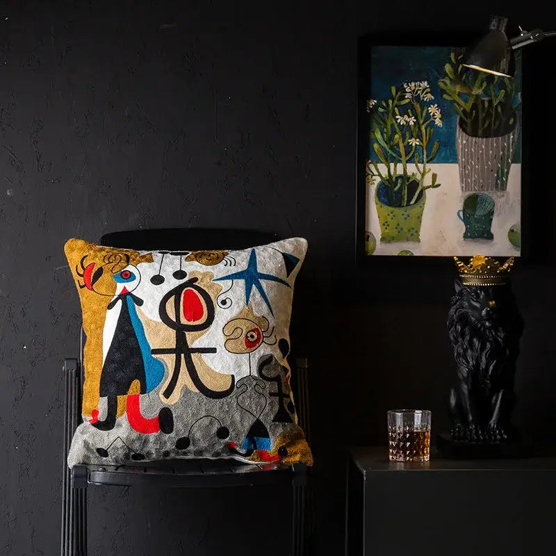 A vibrant decorbites christmas picasso style cushion cover with bold black red blue and gold embroidery on textured fabric