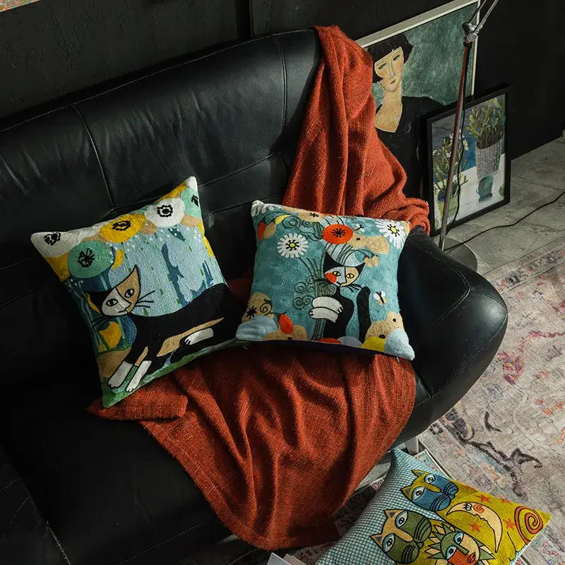 Two embroidered cushion covers with whimsical black and white cats and colorful patterns in decorbites christmas picasso style
