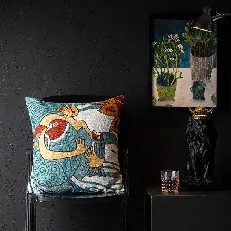 A square cushion cover with vibrant teal and cream embroidered stylized figures decorbites christmas picasso style