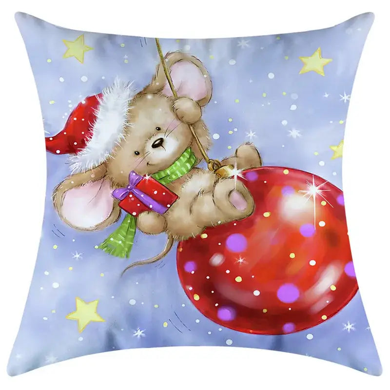 A cozy beige mouse in a santa hat and green scarf hanging on a red ornament on a decorbites christmas pillowcase