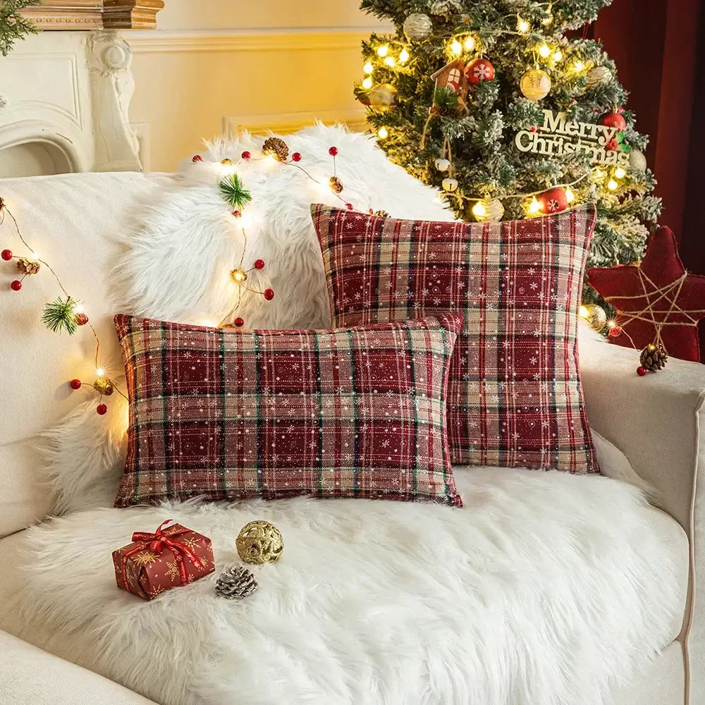 Red and beige decorbites christmas plaid cushion cover with subtle snowflake patterns on white fur sofa