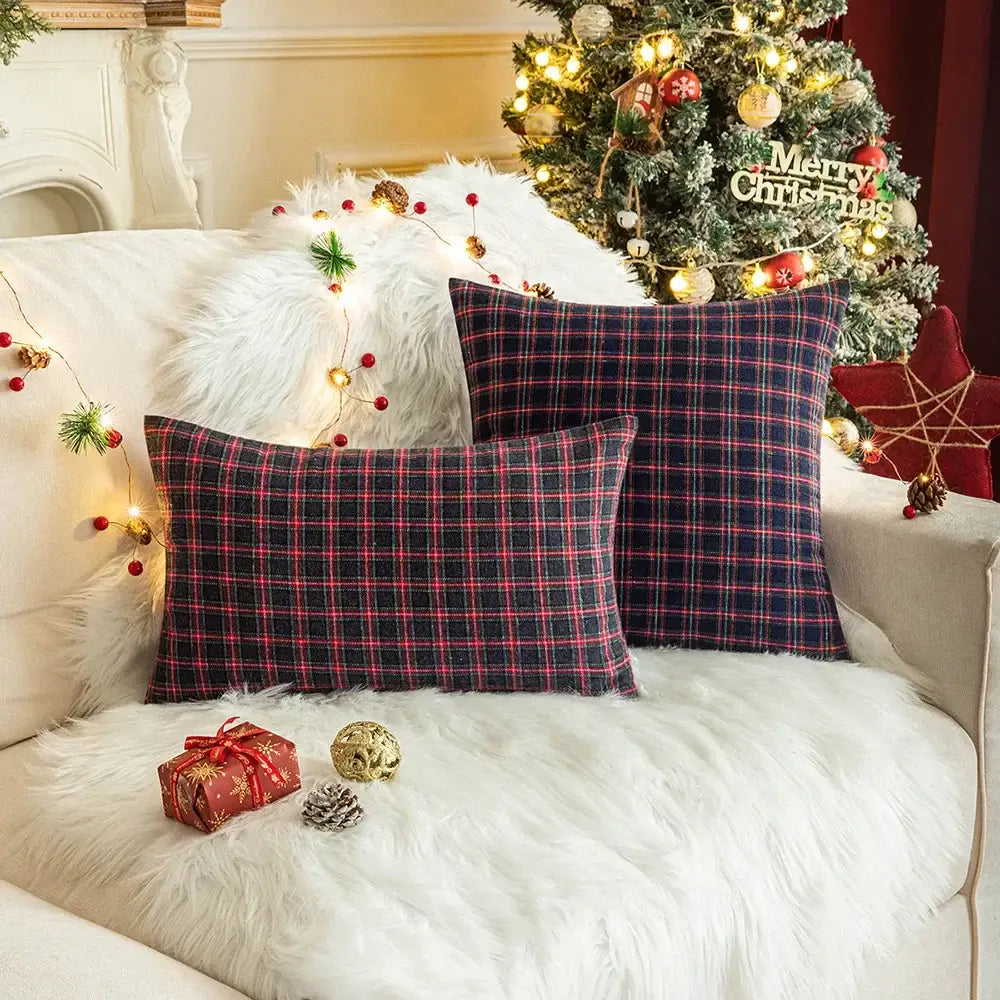 Two decorbites christmas plaid cushion covers in navy and red plaid resting on a white fur couch for home decor