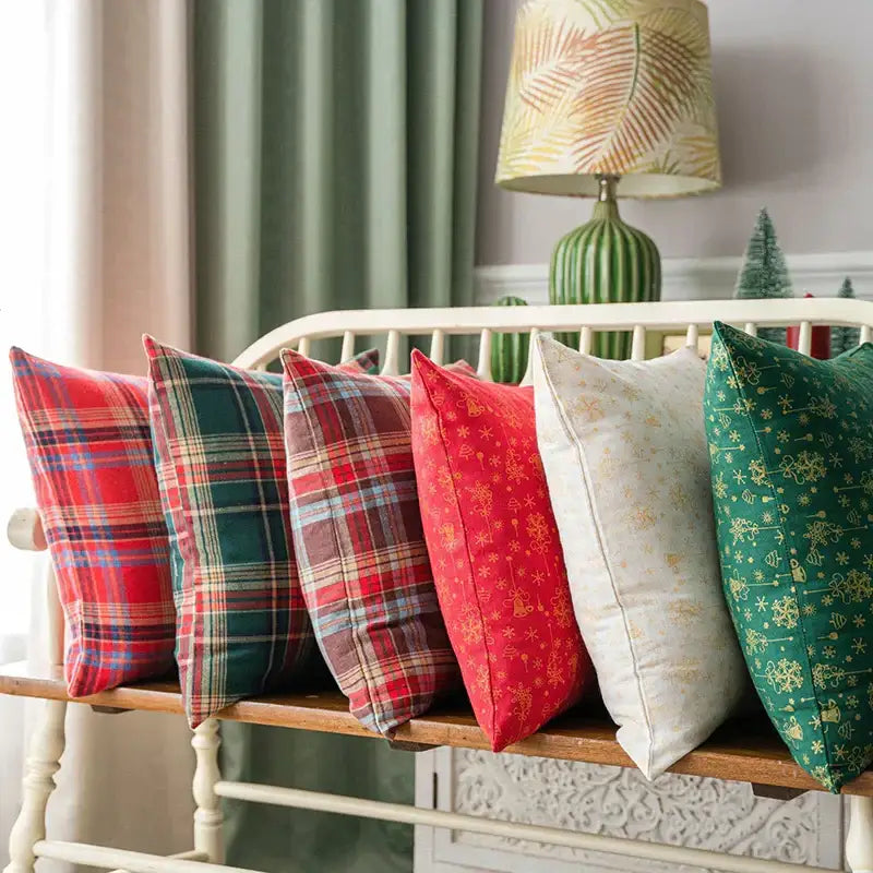 A collection of red green and cream christmas plaid cushion covers with gold snowflake designs by decorbites christmas plaid