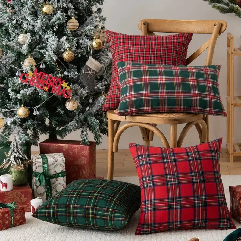 Red and green decorbites christmas plaid pillow covers with black and white accents on wooden chair and floor for holiday decor