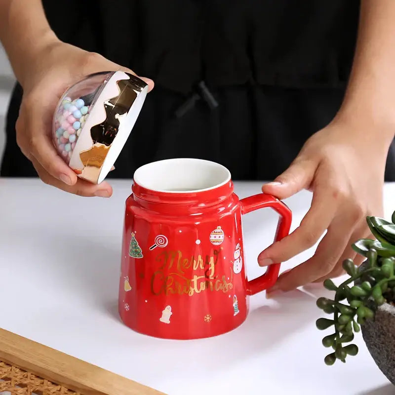 Red ceramic mug with gold foil lettering and lid filled with colorful candies decorbites Christmas planet ceramic mug