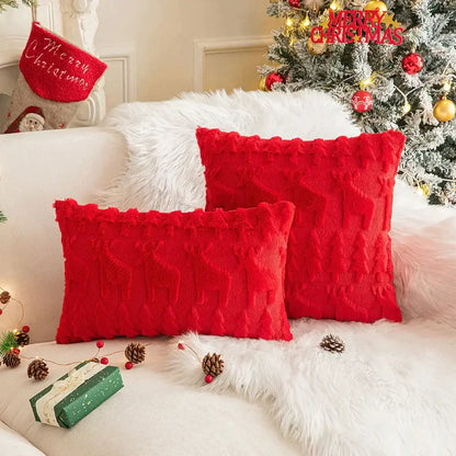 Two vibrant red decorbites christmas plush throw pillows with textured cable knit and frayed edges on white fur blanket