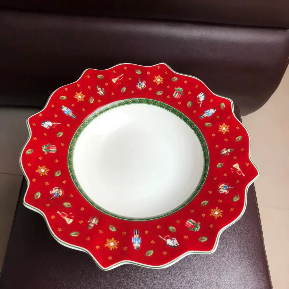 A festive red ceramic plate with scalloped edge featuring miniature nutcracker soldiers in decorbites christmas porcelain tableware set