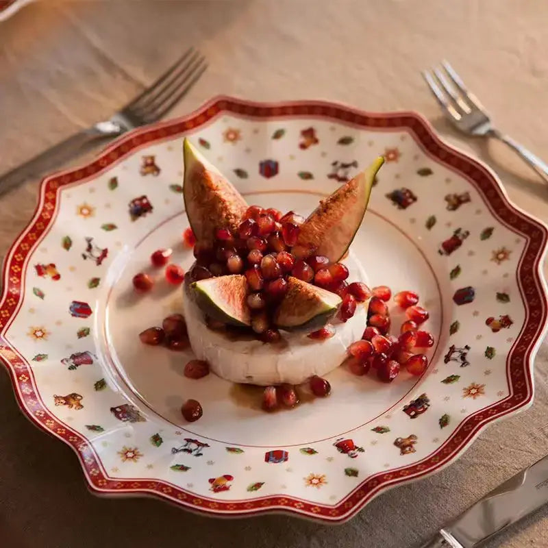 A festive white ceramic plate with scalloped edge and red gold holiday illustrations from decorbites christmas porcelain tableware set