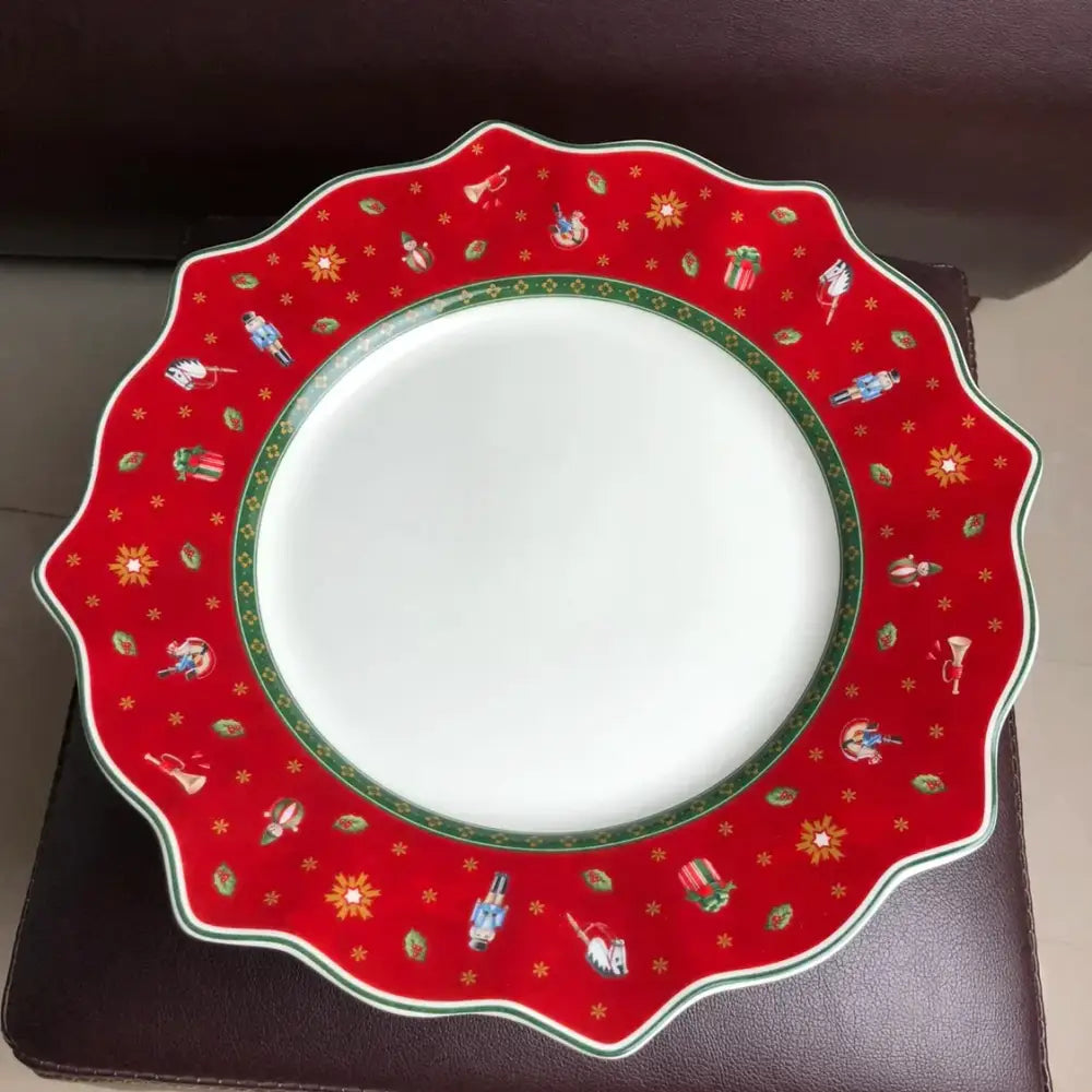 Red ceramic plate with scalloped edges and festive nutcracker pattern from the decorbites christmas porcelain tableware set