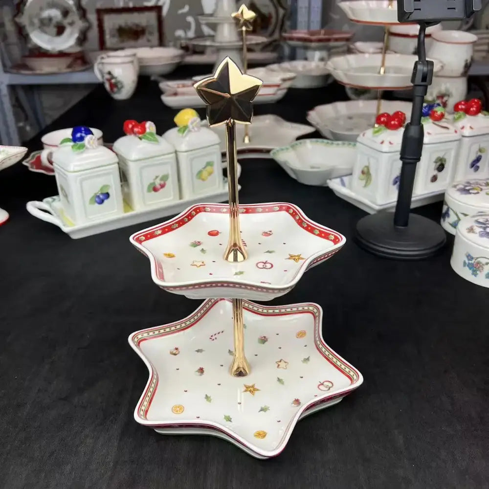 Star-shaped two-tier porcelain dessert stand with red and gold trim featuring festive motifs from decorbites christmas porcelain tableware set