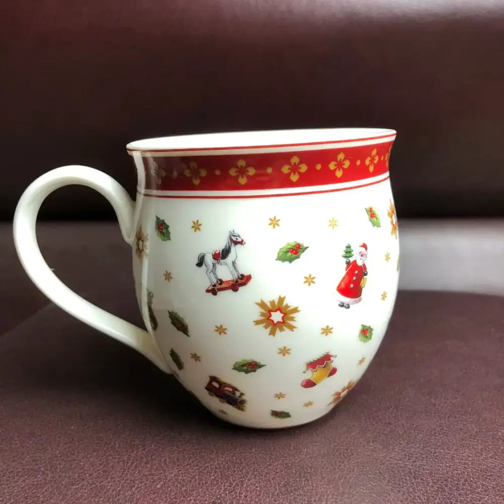 White ceramic mug with festive santa and rocking horse illustrations and red band from decorbites christmas porcelain tableware set