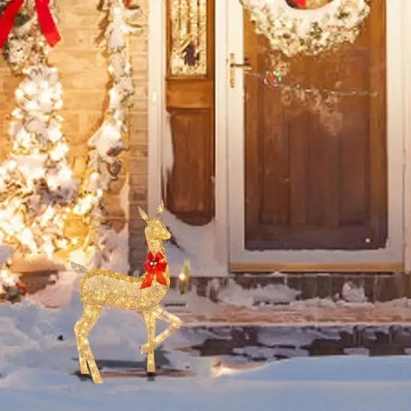 Golden glittering DecorBites christmas reindeer LED light outdoor decor sculpture with a red bow around its neck