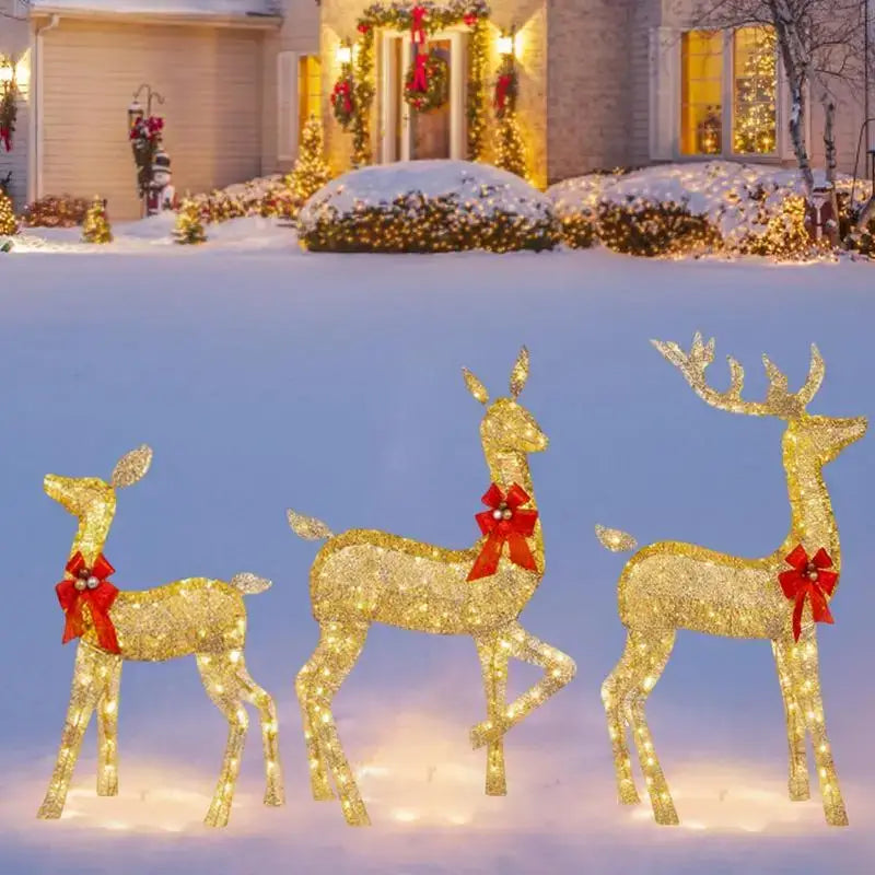 Three illuminated golden DecorBites Christmas reindeer figurines with red bows made of glowing LED light for outdoor decor