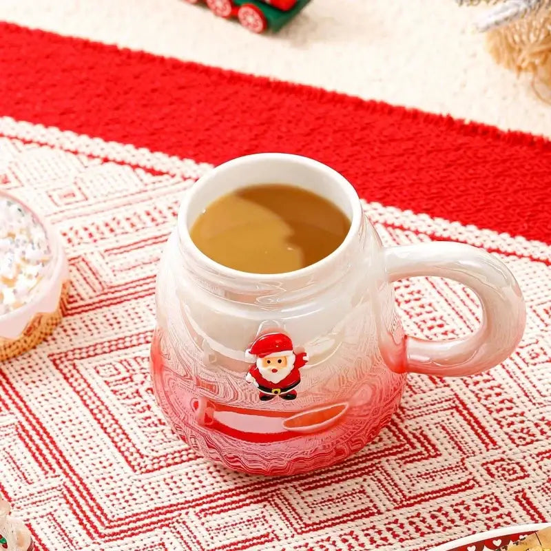 A translucent red and white ceramic mug with santa claus design filled with warm beverage decorbites christmas santa ceramic mug